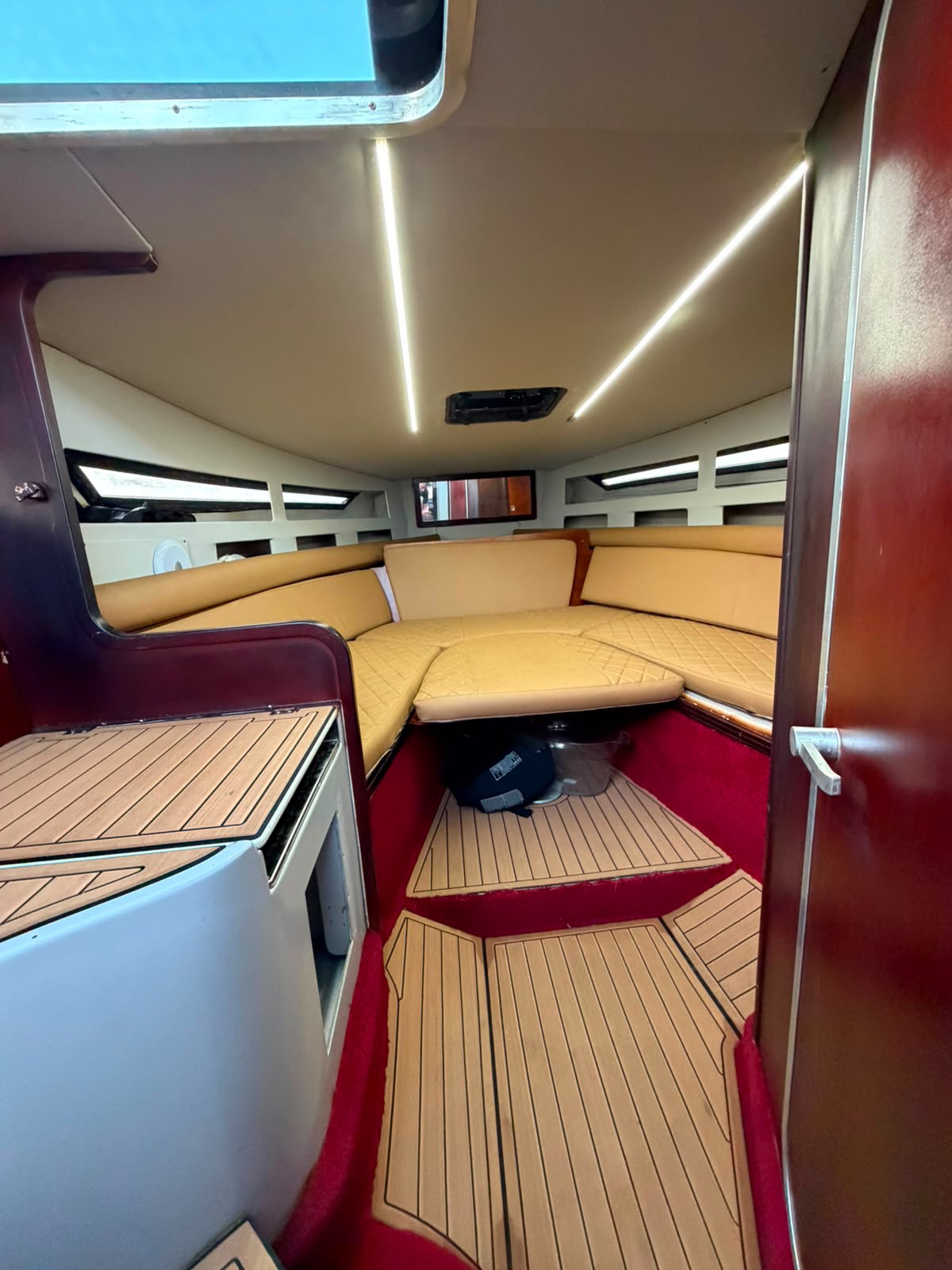 Below-deck cabin with tan cushions and lighting